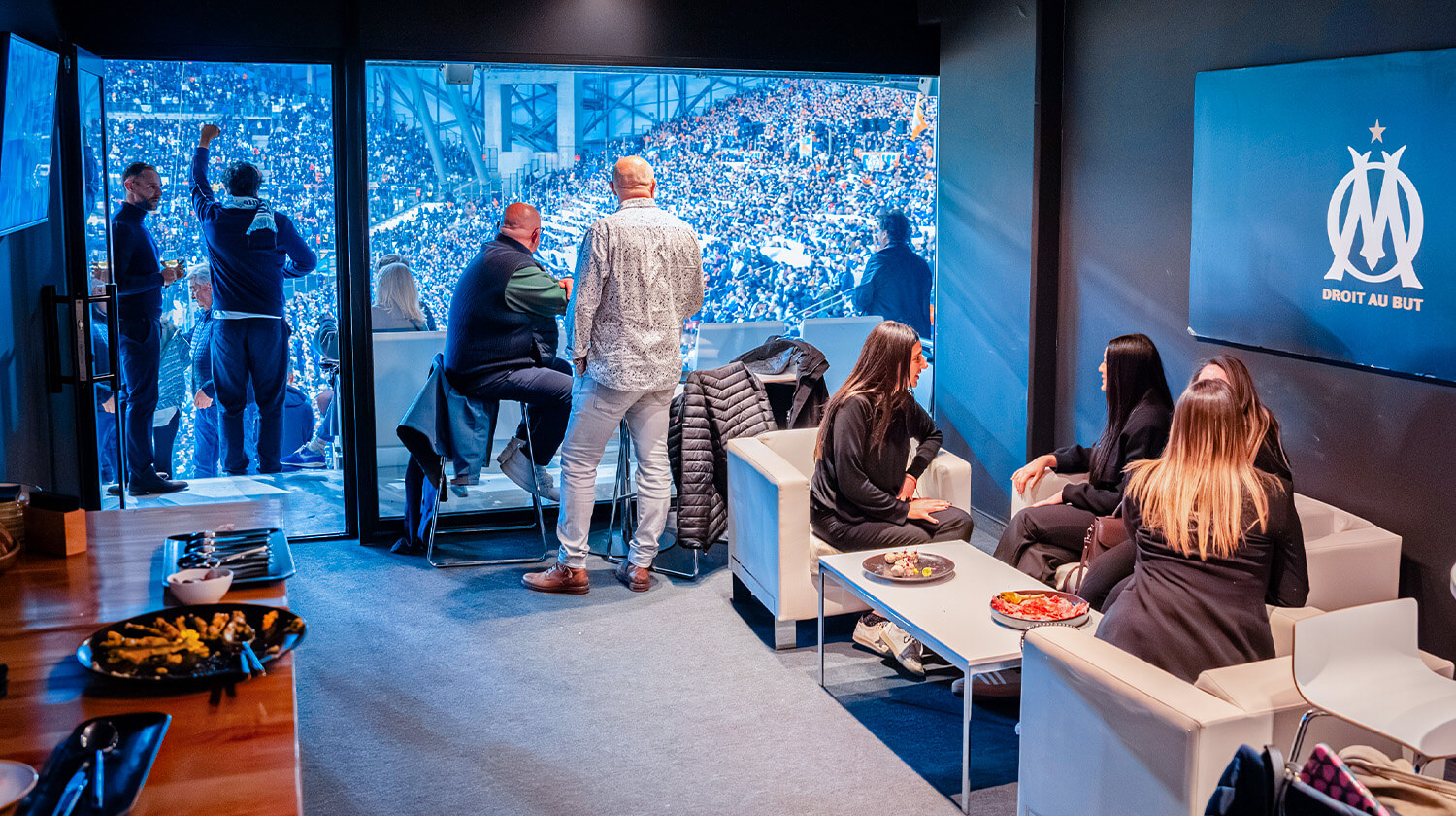 Loge d’hospitalité avec salon, invités et vue sur les tribunes du stade